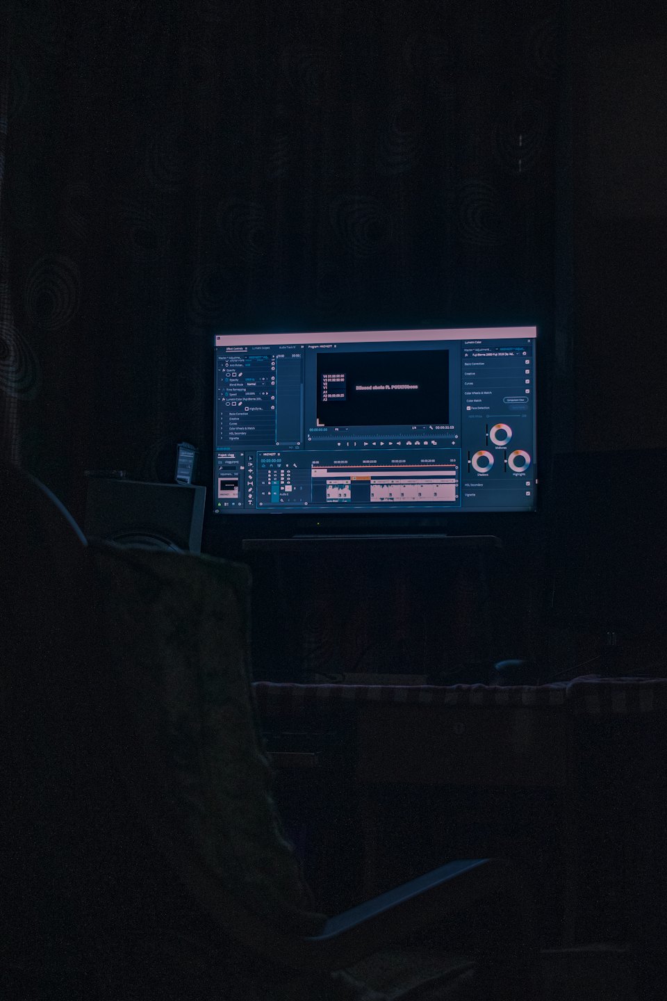 Schermo di un computer con software di video editing in una stanza buia.